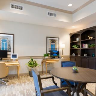 A modern office space featuring desks with computers, comfortable seating, and decorative plants.
