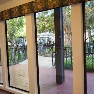 View through large windows overlooking a garden with a patio.