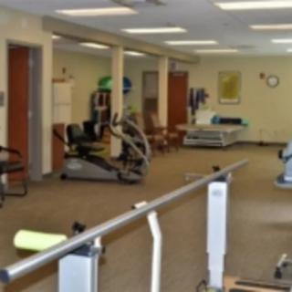 A rehabilitation and physical therapy room with various exercise equipment.