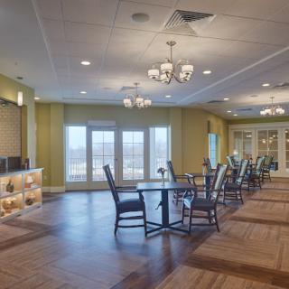 A spacious dining area with elegant chandeliers and large windows.