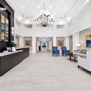 A modern lobby with elegant decor, featuring a chandelier and comfortable seating area.