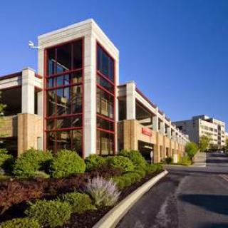 A modern commercial building with landscaped surroundings and a clear blue sky.