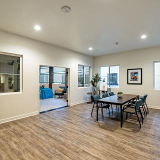 A modern dining room with wooden flooring and minimalist furniture.