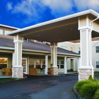 A building with a covered entryway supported by columns.