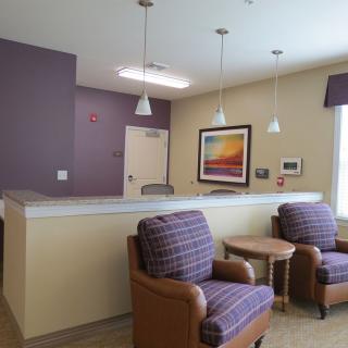 A cozy waiting room with comfortable chairs and soft lighting.