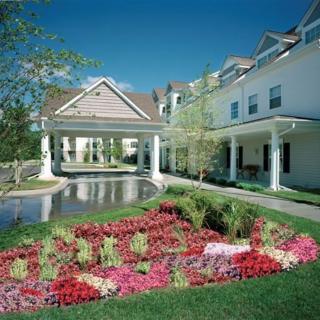 A beautiful garden with vibrant flowers in front of a large residential building.