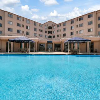 A modern hotel with a large outdoor swimming pool.