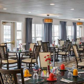 A spacious dining area with neatly arranged tables and chairs, decorated with colorful table settings.