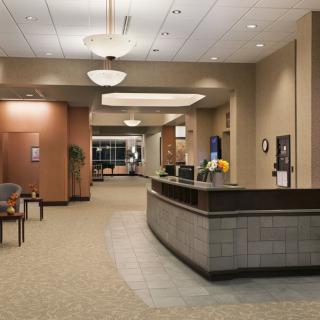 A modern, spacious lobby with a reception desk and seating area.