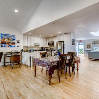A modern open-concept kitchen and dining area with wood flooring.