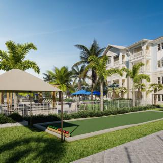 A tropical residential complex with palm trees, a gazebo, and an outdoor pool.