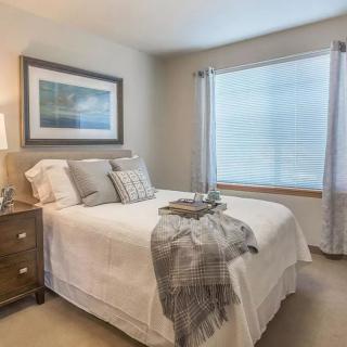 A cozy bedroom with a neatly made bed, soft lighting, and elegant decor.