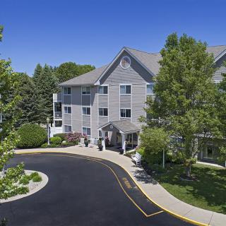 A hotel surrounded by lush greenery with a clear blue sky.