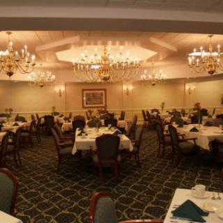 An elegantly decorated banquet hall with chandeliers and neatly arranged dining tables.