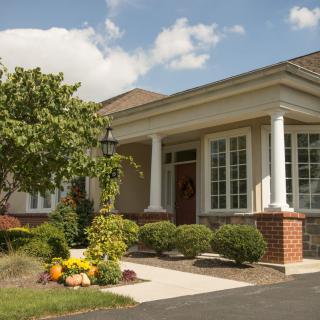 A suburban house with a landscaped front yard and prominent columns.
