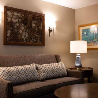 A cozy living room with a comfortable sofa, decorative pillows, and ambient lighting from a table lamp.
