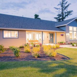 A well-maintained suburban house with a landscaped front yard during the evening.