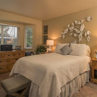 A cozy bedroom with elegant decor, featuring a comfortable bed, warm lighting, and decorative wall art.