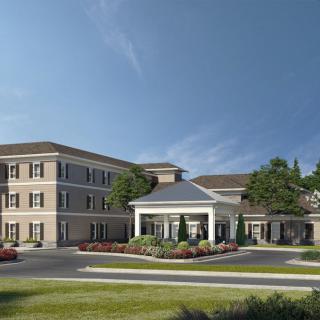 A modern building with a well-maintained landscape and clear blue sky.