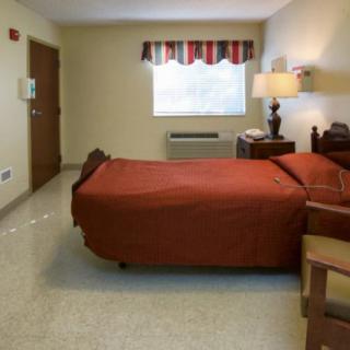 A simple bedroom with a single bed and cozy lighting.
