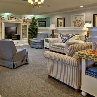 A cozy living room featuring comfortable sofas, armchairs, and a television set.