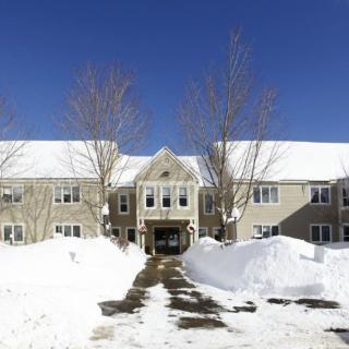 A building surrounded by snow under a clear blue sky.