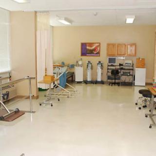 An empty medical clinic room with various equipment and furniture.
