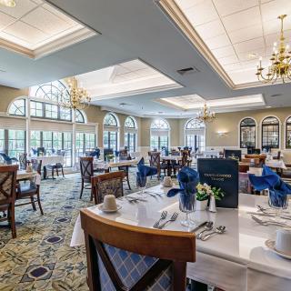 An elegant dining area with chandeliers and large windows, offering a bright and inviting atmosphere.