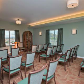 A spacious waiting area with neatly arranged chairs and calming green walls.