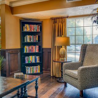 Cozy living room with a bookshelf and comfortable armchair by the window.