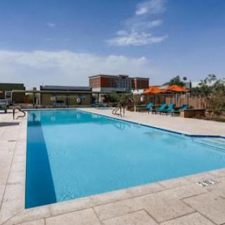 A serene outdoor swimming pool under a clear blue sky, perfect for relaxation and leisure.