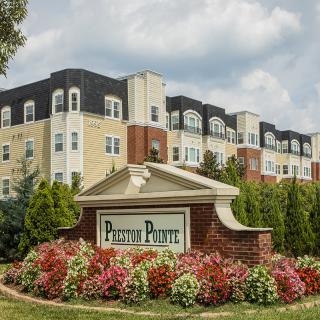 A well-maintained apartment complex with vibrant landscaping and prominent signage.