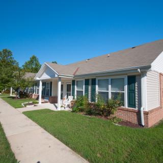 A suburban house with a well-maintained lawn and a clear blue sky.