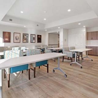 A spacious and modern meeting room with neatly arranged tables and chairs.