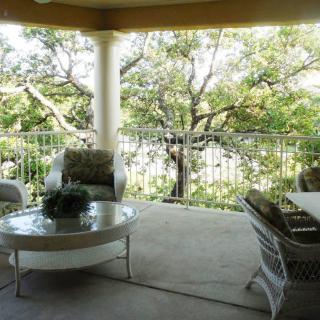 A cozy patio with comfortable seating and a view of lush greenery.