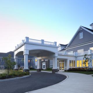 A modern residential building featuring a welcoming entrance and landscaped surroundings.
