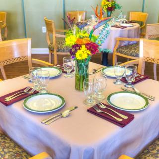 An elegantly set dining table with floral centerpiece in a restaurant.