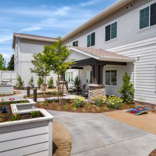 A well-landscaped residential outdoor patio area with a paved walkway and garden.