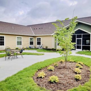 A modern building with a landscaped garden and patio seating.