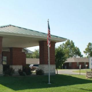 A small brick building with an American flag on a sunny day.