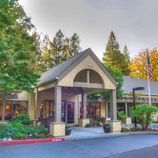 A welcoming building entrance surrounded by trees and greenery.
