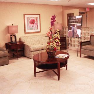 A cozy waiting area featuring comfortable sofas and a decorative coffee table with flowers.