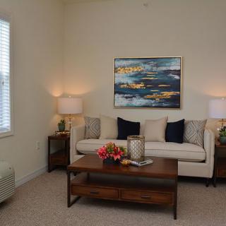 Cozy living room with a comfortable sofa, stylish artwork, and warm lighting.