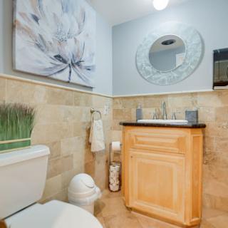 A beautifully designed bathroom featuring elegant wall art, a modern sink, and a stylish mirror.