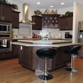 A modern kitchen with a central island and sleek bar stools.