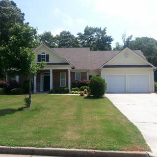A suburban house with a well-maintained lawn and a two-car garage.