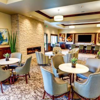 A modern lounge with comfortable seating, a fireplace, and decorative artworks.