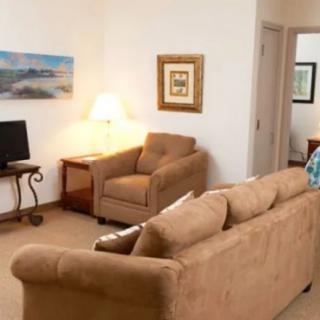 A cozy living room with comfortable seating and decorative elements.