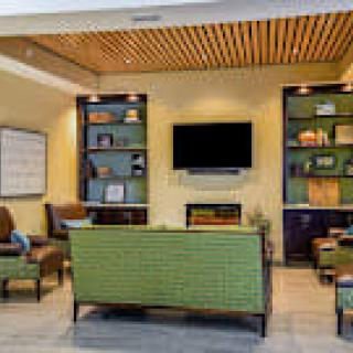 A modern lounge area with comfortable seating, a television, and decorative shelves.