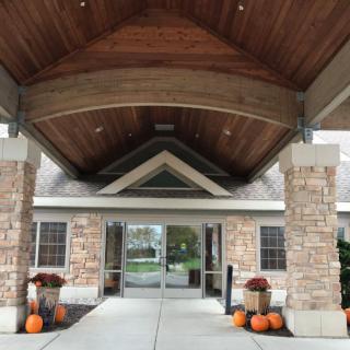 An entrance to a building decorated with pumpkins and autumn-themed decor.